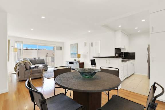 A modern kitchen with a dining table and chairs.
