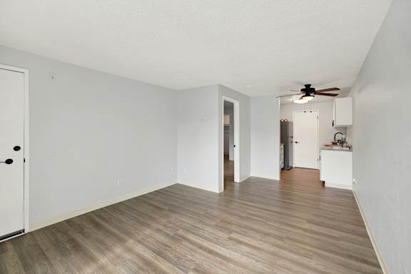A room with a wooden floor and a ceiling fan.