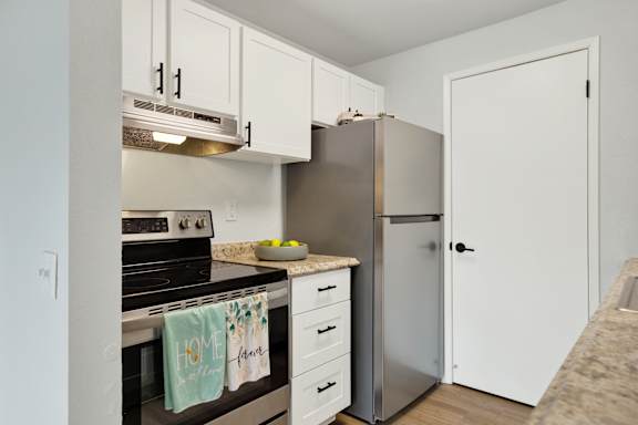 A kitchen with a stove top oven and a refrigerator.