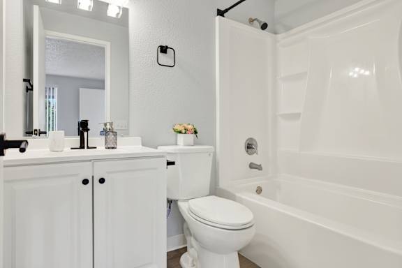 A white toilet sits next to a white sink in a bathroom.