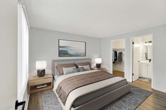 A bedroom with a large bed and a painting on the wall.