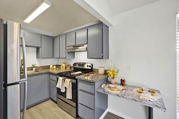 A kitchen with a stove, oven, and refrigerator.