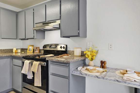 A kitchen with a black stove top oven and a marble counter top.