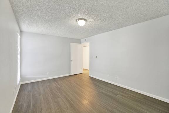 A room with a light brown floor and a white ceiling with a light fixture.