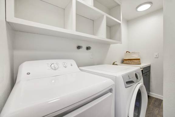 A white washing machine and dryer in a laundry room.