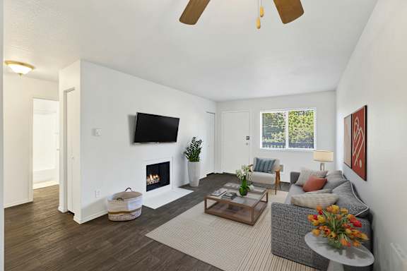 A living room with a fireplace and a flat screen TV mounted on the wall.