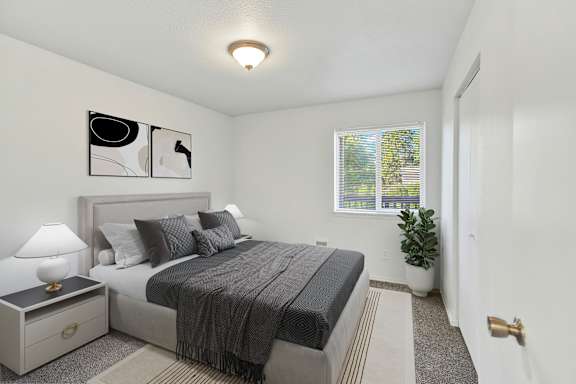 A bedroom with a bed, nightstand, and lamp.