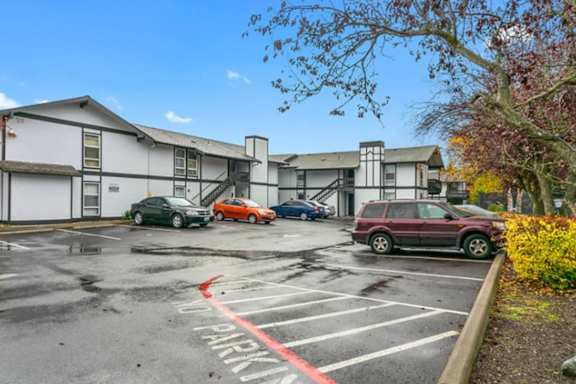 a parking lot with cars in front of a building