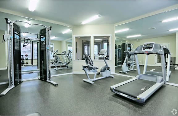 a gym with cardio equipment and weights at  Sunset Park Apartments in Seattle, WA