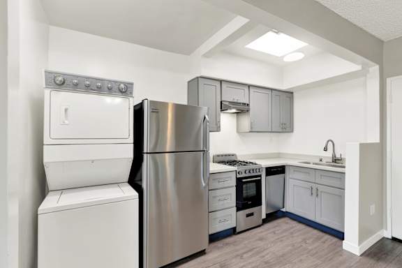 A kitchen with a stainless steel refrigerator, dishwasher, and oven.at Federal Apartments, Los Angeles, CA