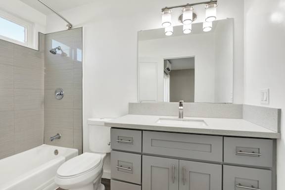 A white bathroom with a sink, toilet, and bathtub.at Federal Apartments, California, 90025