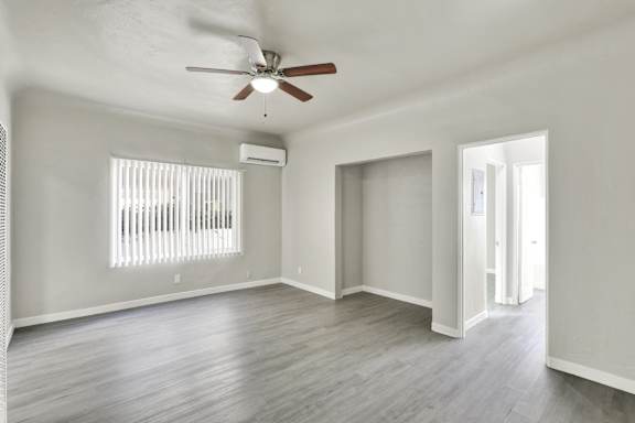 A room with a ceiling fan and a window with blinds.at Barton Apartments, Los Angeles, CA 90038