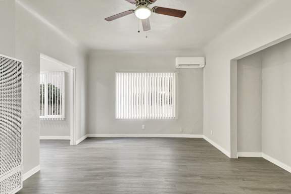 A room with a ceiling fan and a window with blinds.at Barton Apartments, Los Angeles
