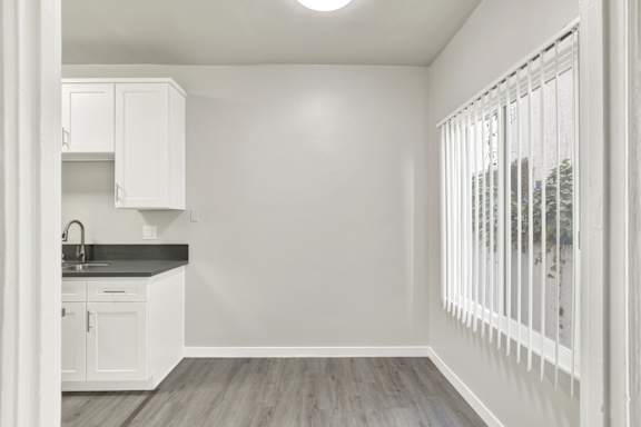 A kitchen with white cabinets and a black countertop.at Barton Apartments, Los Angeles California
