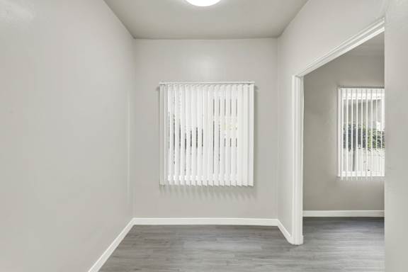 A room with a window covered by white blinds.at Barton Apartments, Los Angeles, CA