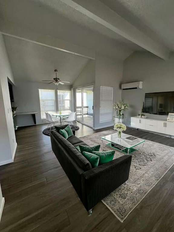 A living room with a black couch and a glass coffee table.