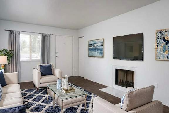 A living room with a fireplace, two chairs, and a coffee table.