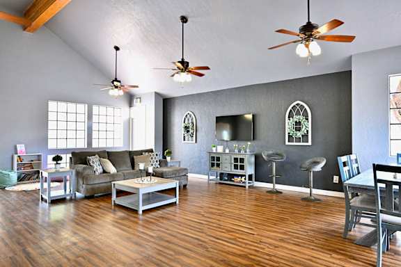 A living room with a grey couch and a wooden floor.