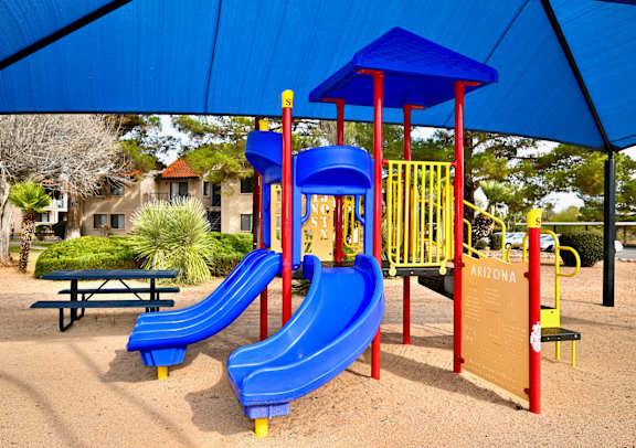 A playground with a blue slide and a red and yellow structure.