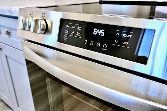 A stainless steel oven with a digital display showing 645 degrees and buttons for various functions.