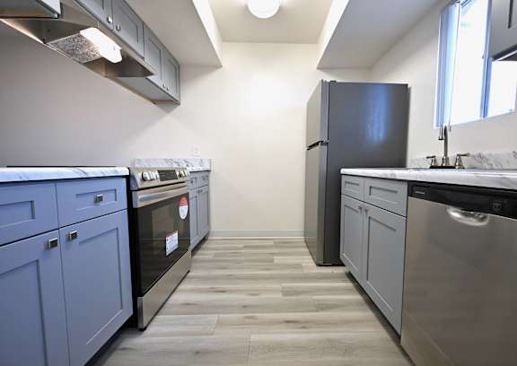 A kitchen with a black fridge and a black dishwasher.