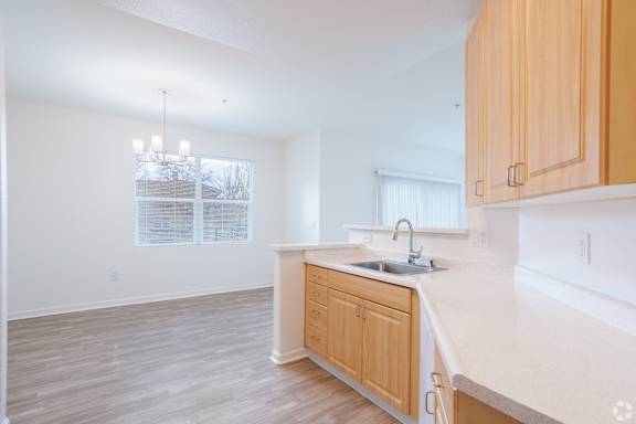 A kitchen with wooden cabinets and a white countertop.