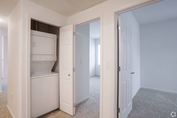 A white refrigerator is in a kitchen with a white door. at Cornerstone at Gale Ranch Apartments, San Ramon, CA
