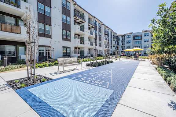 a bench and umbrella in front of an apartment building at Deer Creek Apartments, San Ramon, CA