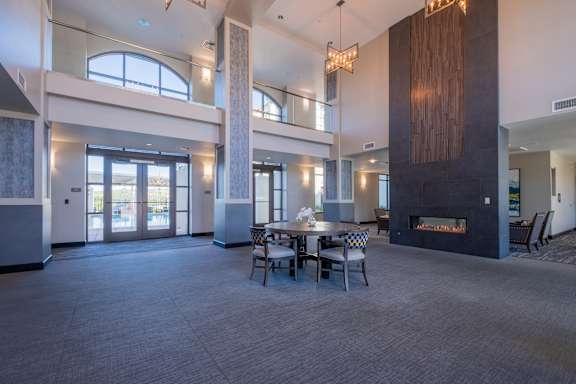 a large room with a table and chairs in front of a fireplace at Deer Creek Apartments, San Ramon, CA