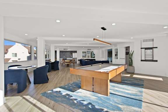A modern living room with a blue rug and a wooden coffee table  at Harvard Manor, Irvine, CA