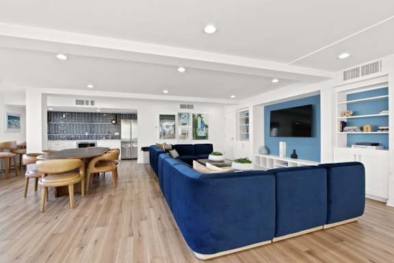 A modern living room with a blue sofa and wooden floors  at Harvard Manor, Irvine, CA