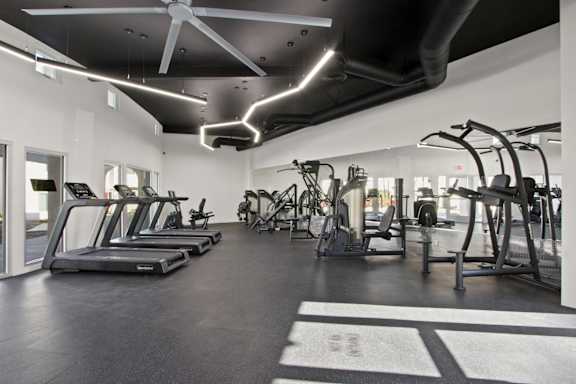 A gym with treadmills, elliptical machines, and other exercise equipment  at Harvard Manor, Irvine, CA
