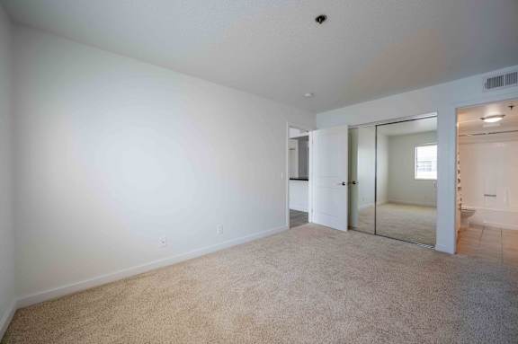a bedroom with white walls and carpet