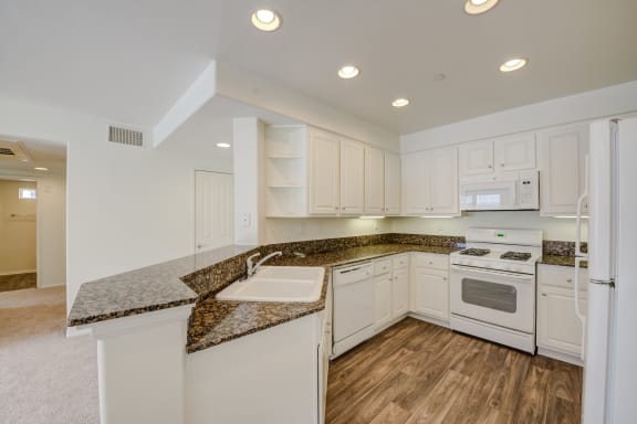 a kitchen with white cabinets and granite countertops  at Monarch at Dos Vientos, Newbury Park, CA