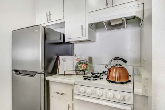 a kitchen with a stove top oven next to a refrigerator
