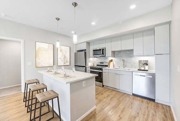 The Overlook Santa Clarita in CA&#x27;s modern kitchen with an island and stools.