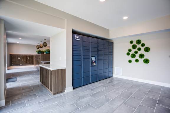 A modern lobby with a reception desk and a large wall art at Pradera Apartments, California