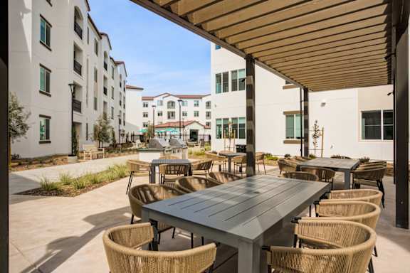 A patio with a table and chairs is surrounded by buildings.