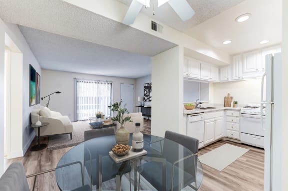 a living room with a glass table and a kitchen in the background at Redlands Park Apts, Redlands, CA, 92373