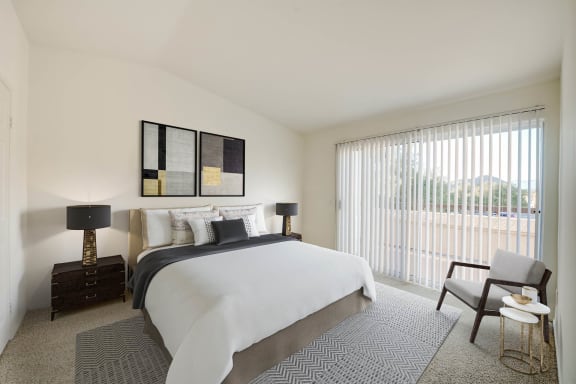 a bedroom with a bed and a chair in a room