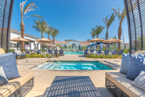 a resort style swimming pool with lounge chairs and umbrellas  at Montecito Apartments at Carlsbad, Carlsbad, 92010