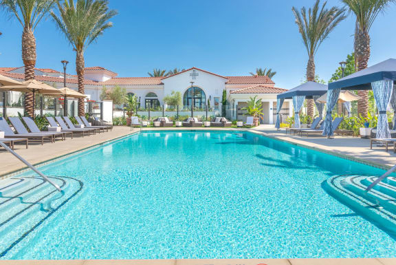 a resort style swimming pool with lounge chairs and umbrellas  at Montecito Apartments at Carlsbad, Carlsbad