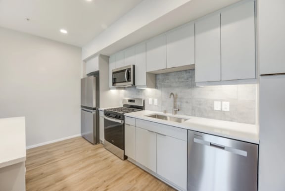 a kitchen with white cabinets and stainless steel appliances at The Overlook Santa Clarita, California