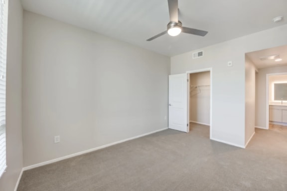 an empty living room with a ceiling fan and a closet at The Overlook Santa Clarita, California