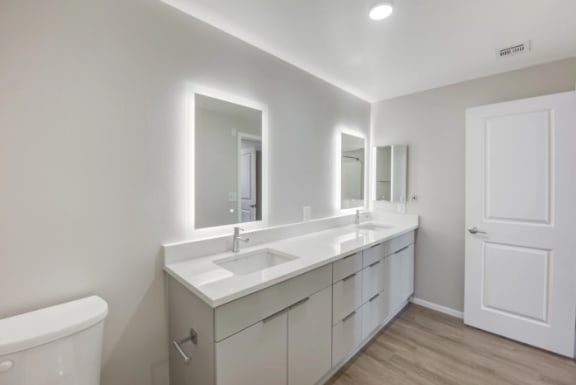 a white bathroom with two sinks and two mirrors at The Overlook Santa Clarita, California