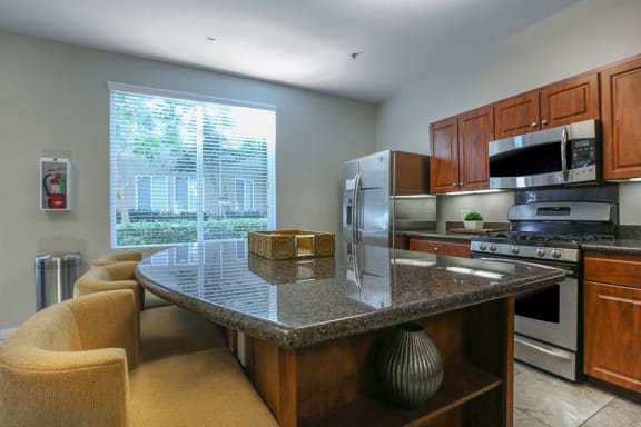 a kitchen with a granite counter top and stainless steel appliances at Tesoro Senior Apartments, California, 91326