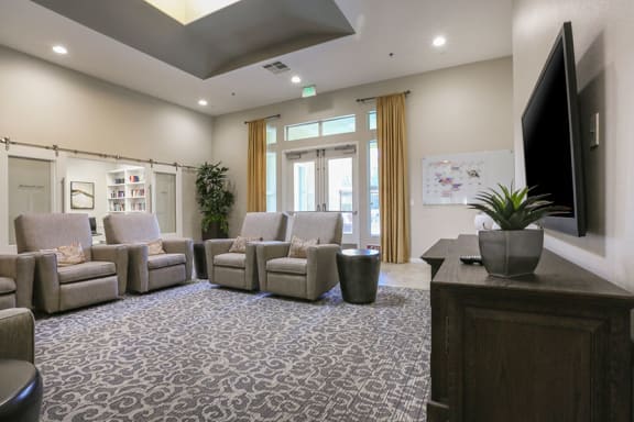 a waiting room with chairs and a tv  at Tesoro Senior Apartments, Porter Ranch, CA