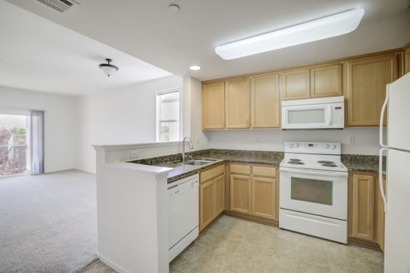 a kitchen with white appliances and wooden cabinets  at Valencia at Gale Ranch, San Ramon