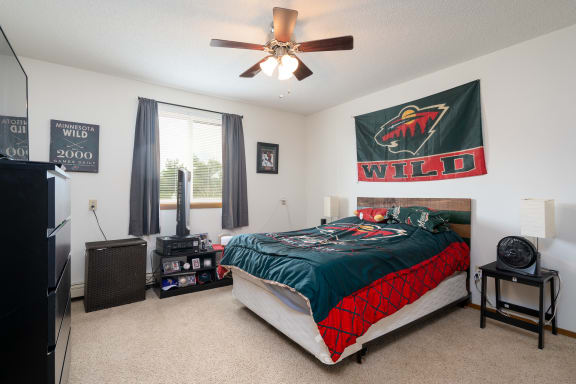 the master bedroom has a comfy bed and a ceiling fan