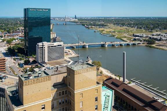 A cityscape with a river and a bridge in the background.